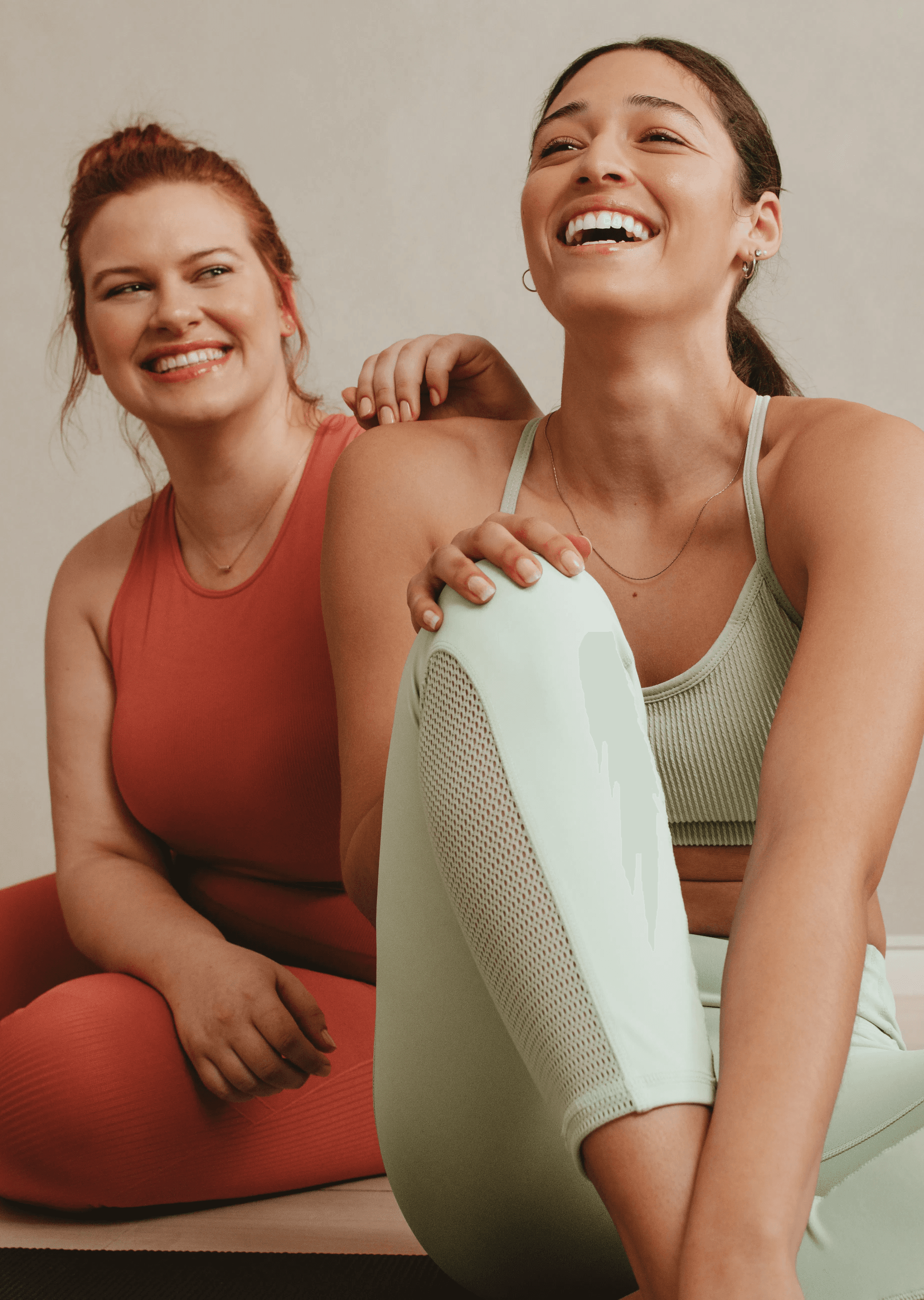 Two women in athletic wear smiling