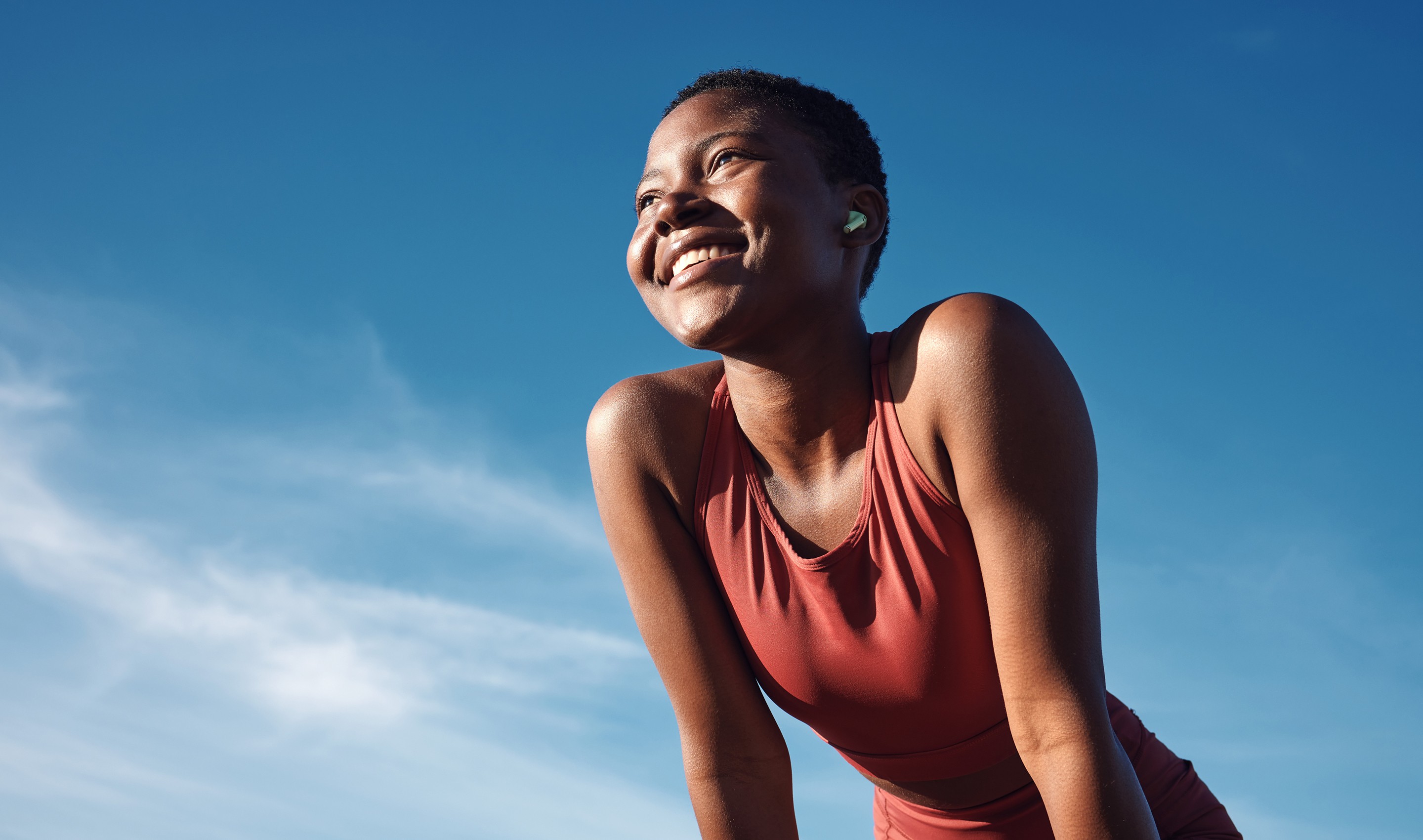 Woman in athletic wear smiling with headphones
